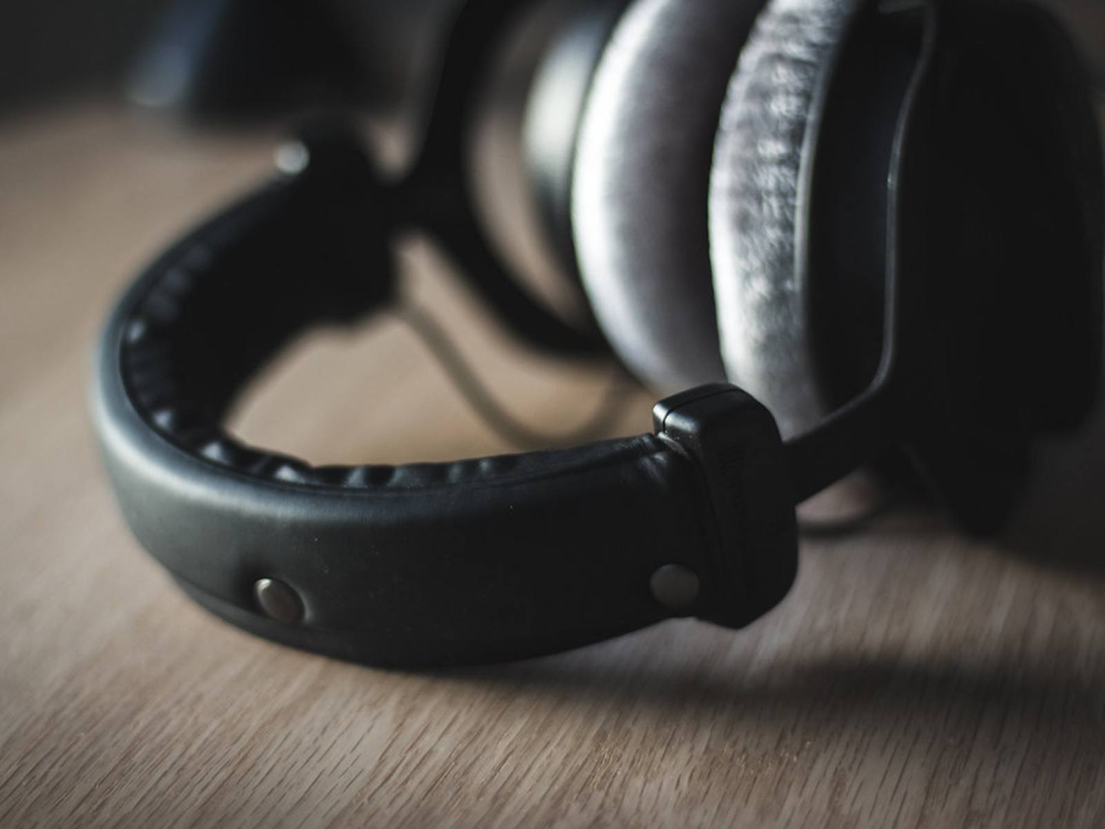 A pair of headphones resting on an open laptop, representing audio description and closed captioning work.